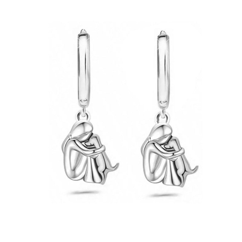 A little girl and a dog embrace earrings